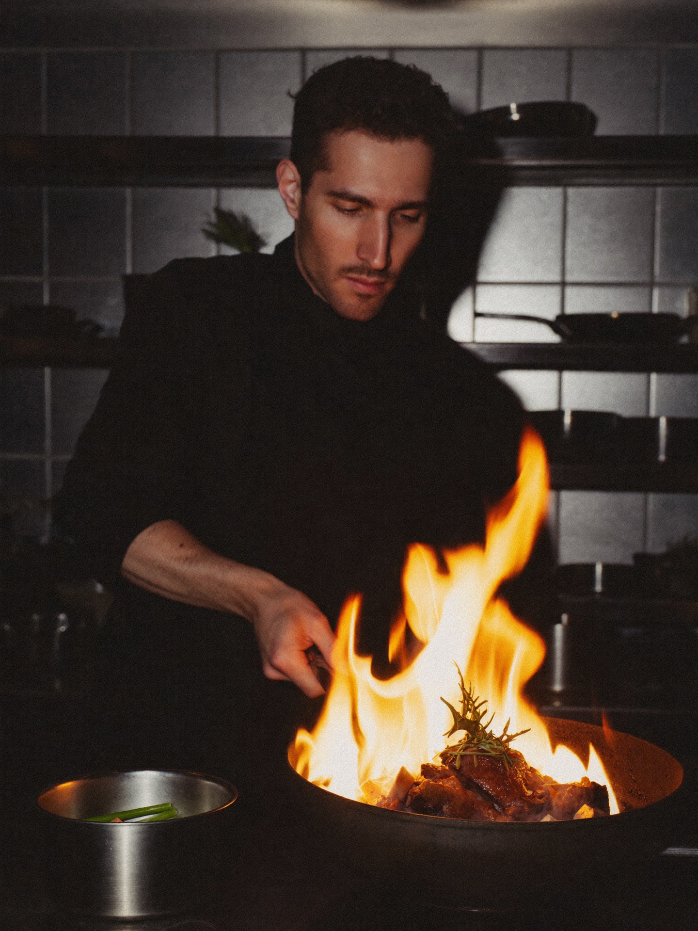 Küchenchef Jonas Reber richtet ein Gericht über offener Flamme an